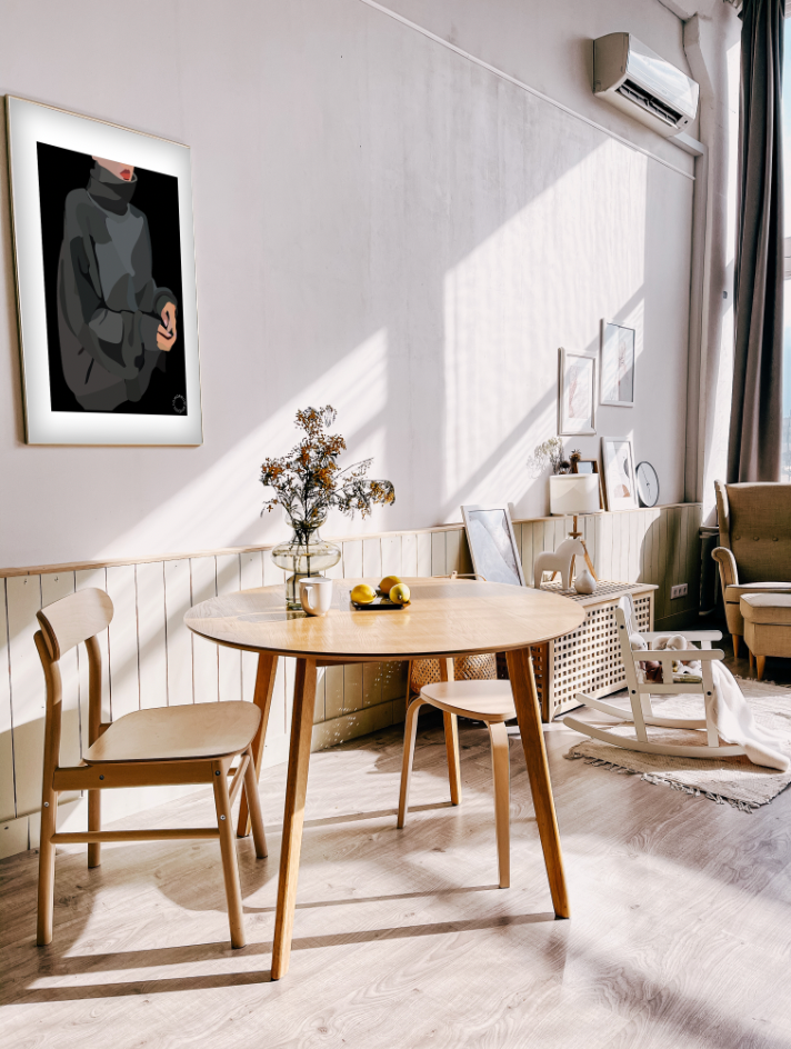 En lille stue med et rundt spisebord i træ med træstole til. På væggen hænger der en Kreativ Kunstplakat i grafisk design af en kvinde i turtleneck